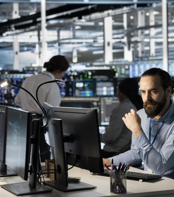 Technician using PC in data center to update server tech, configuring equipment using software tools. Server room employee reviewing hardware analytics, ensuring reliable network operations